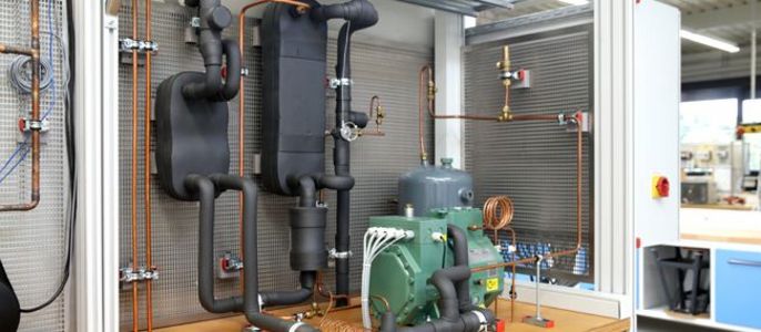 Ein komplexes System von Rohrleitungen und Maschinen, das vermutlich Teil einer größeren Industrieanlage ist und verschiedene Komponenten wie Ventile, Filter und Kompressoren enthält.