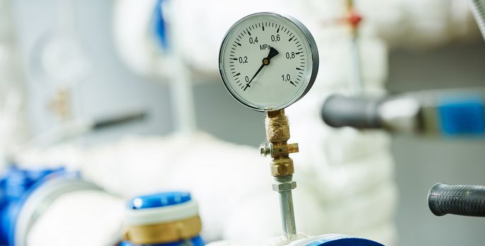 Ein Manometer, das an ein blau-weißes System angeschlossen ist, mit einem Messwert von 0,2.