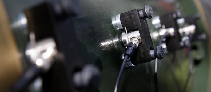 Mehrere schwarze Geräte, die über schwarze Kabel mit einer grünen Fläche verbunden sind.