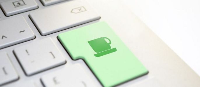 Eine Computertastatur mit einer grünen Taste, auf der das Symbol einer Tasse abgebildet ist.