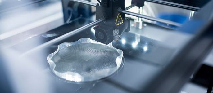 Ein 3D-Drucker in Aktion, der ein transparentes Objekt mit komplizierten Mustern herstellt.