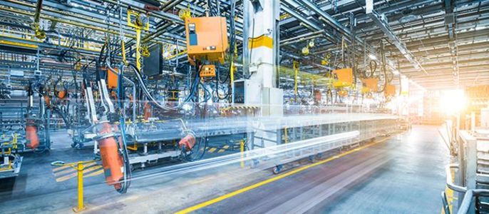 Eine industrielle Umgebung mit verschiedenen Maschinen, Rohren und Förderanlagen, die alle miteinander verbunden und in Bewegung sind.