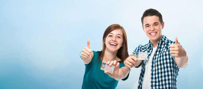 Zwei Personen, ein Mann und eine Frau, zeigen beide mit ihren Händen den Daumen nach oben. Sie halten ihre Ausweise hoch.