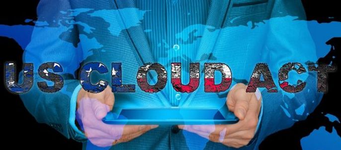 Ein Mann im Anzug hält ein Tablet in der Hand, auf dem die Worte "US CLOUD ACT" vor dem Hintergrund einer Weltkarte zu lesen sind.